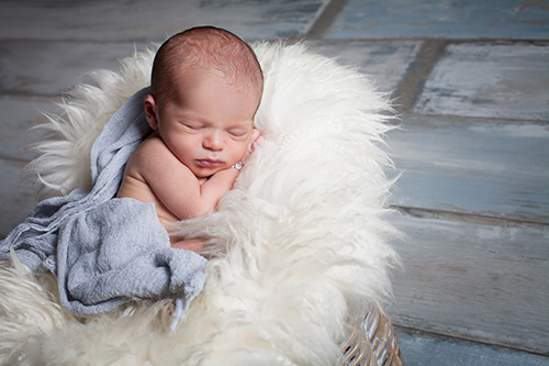 Fotograf Baby Düsseldorf: Neugeborenes schläft in weichem Schafsfell