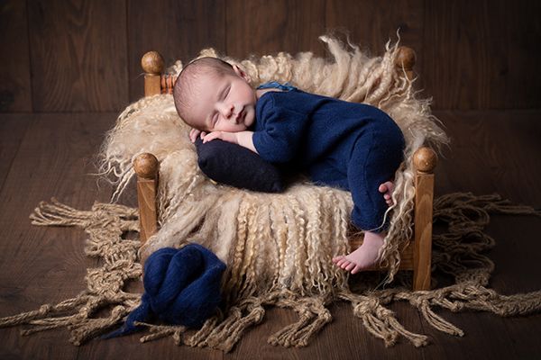 Babyfotografie mit Accessoire babyfotografie Düsseldorf. Ein Baby liegt in gemütlichem babybett