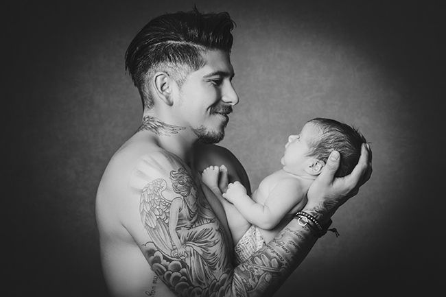 Schwarz-Weiß Babyfotografie Düsseldorf – Vater hält sein Neugeborenes behutsam im Studio