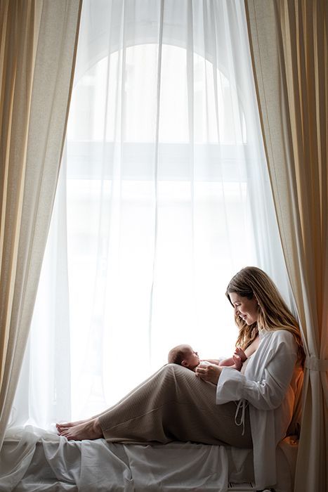 Babyfotografie mit Mutter im Studio in Düsseldorf – Neugeborenes liegt geborgen im natürlichen Fensterlicht