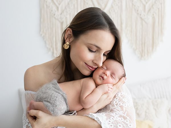 Babyfotografie mit Mutter im Studio in Düsseldorf – Neugeborenes schläft geborgen an der Wange seiner Mutter