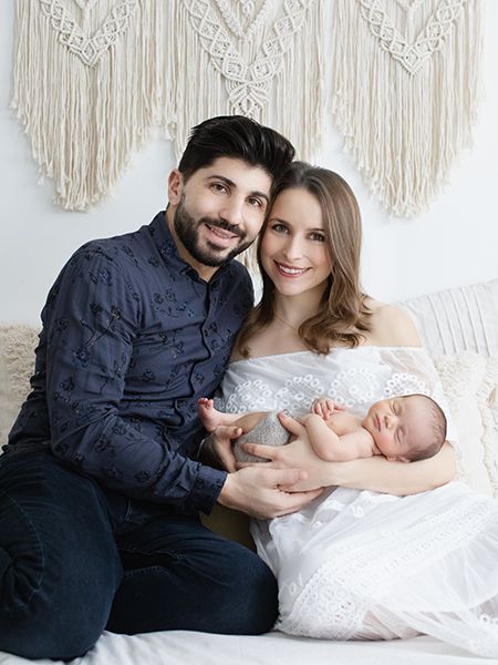 Babyfotografie mit Eltern im Studio in Düsseldorf – Mutter und Vater halten ihr Neugeborenes gemeinsam im Arm
