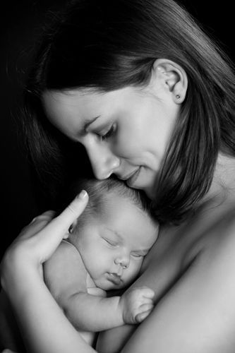 Schwarzweiß Babyfoto im Studio Düsseldorf: Mutter hält ihr schlafendes Neugeborenes liebevoll im Arm